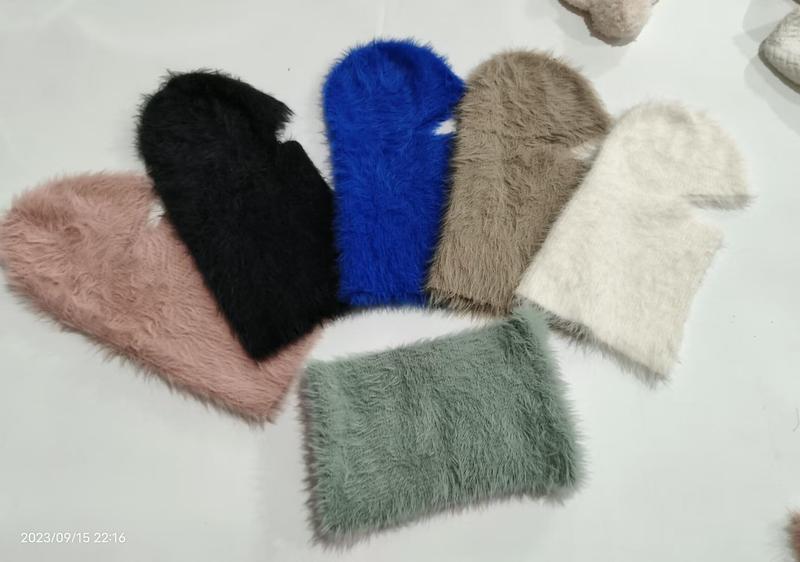 Sechs flauschige Kunstfell-Balaclavas in einem Fächer-Layout in Pink, Schwarz, Blau, Taupe, Creme und Salbeigrün