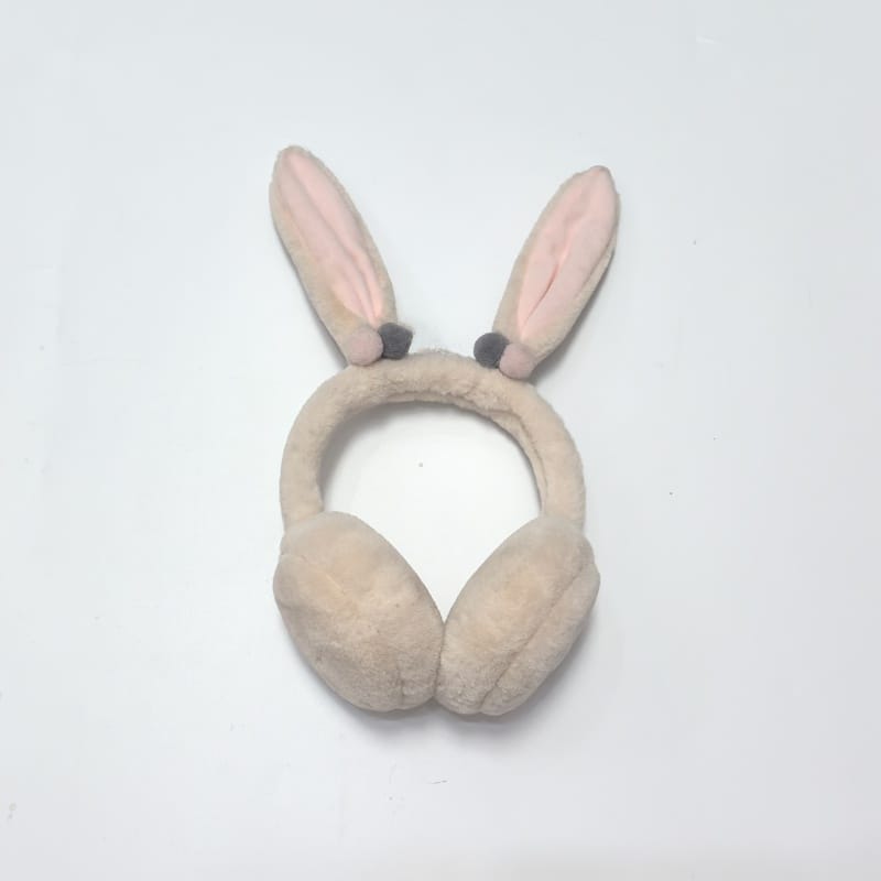 Beige flauschige Kunstfell-Ohrenschützer mit weichem Stirnband auf weißem Hintergrund, gemütliche Winterohrenmuscheln