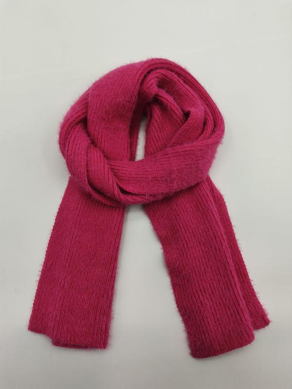 Leuchtend fuchsiafarbener Rippenstrickschal, zu einer Schlaufe gefaltet auf weißem Hintergrund, weiches flauschiges Garn sichtbar