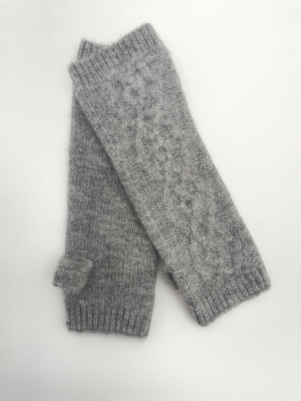 Paar graue fingerlose Handschuhe mit Zopfstrickmuster, Rippenbündchen und Daumenaussparung, flach auf weißem Untergrund