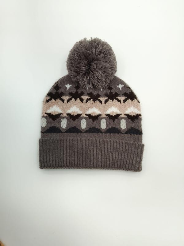 Grau gestrickte Wintermütze mit Fair-Isle-Motiven in Rosa, Braun und Weiß sowie flauschigem Bommel auf der Spitze, Studioaufnahme