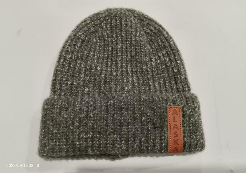 Graumelierte gerippte Strickmütze mit Umschlagkrempe und braunem Leder-Patch mit Alaska-Schriftzug auf der Krempe