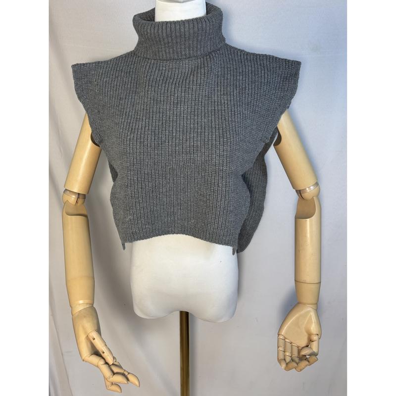 Ärmellose Strickweste in Grau mit Rollkragen und Rippenstruktur auf einer Schaufensterpuppe mit Holzarmen