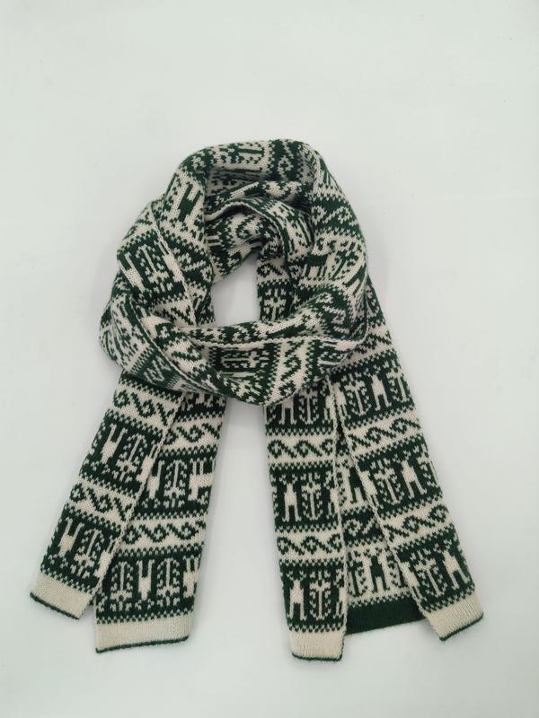Gefalteter grün-cremefarbener Strickschal mit geometrischem Fair-Isle-Muster aus der Vogelperspektive auf weißem Hintergrund