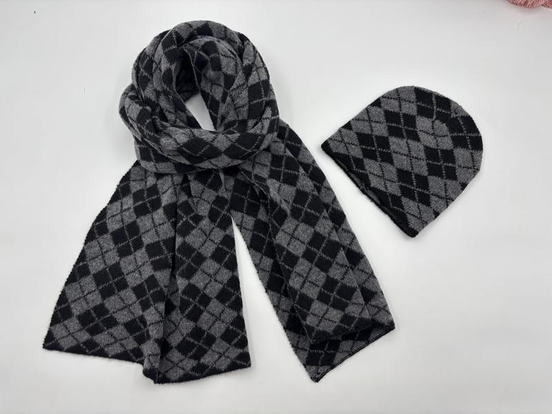 Strickmütze und passender Schal mit klassischem Argyle-Rautenmuster in Grau und Schwarz, flach auf weißem Hintergrund