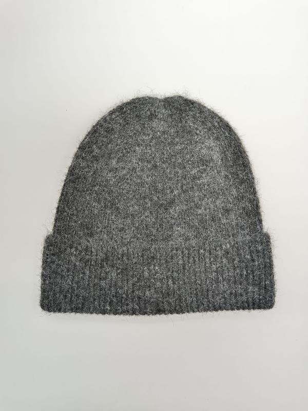 Weiche, flauschige Strickmütze in Grau mit breitem Rippenbündchen, flach fotografiert auf weißem Untergrund