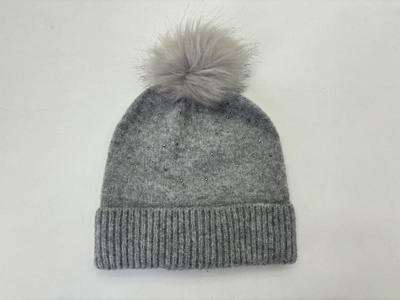 Hellgraue Wintermütze aus Strickstoff mit fluffigem Kunstfell-Pompom und funkelnden Kristallsteinen am Rippenbündchen