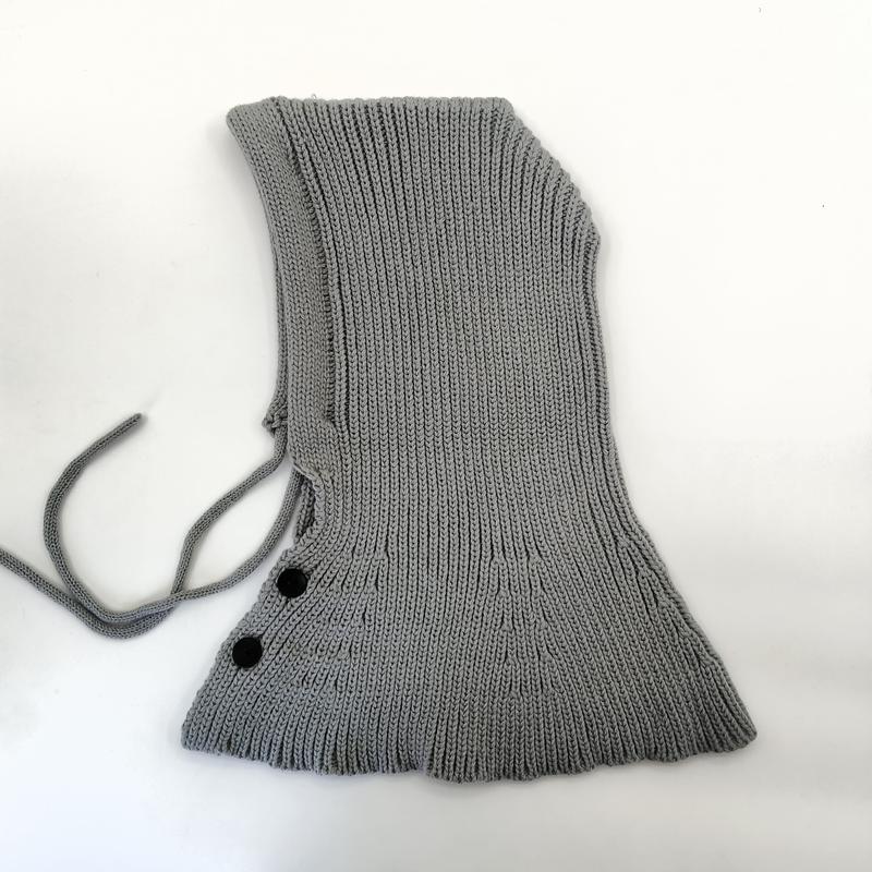 Hellgrauer Strick-Balaclava mit verstellbaren Kordeln und zwei schwarzen Knopfverschlüssen auf weißem Hintergrund