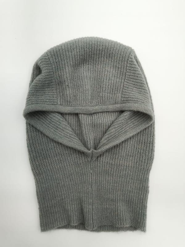 Graue Strick-Balaclava mit Rippenmuster als Gesichtsschutz, offene Gesichtsöffnung, Draufsicht auf weißem Untergrund