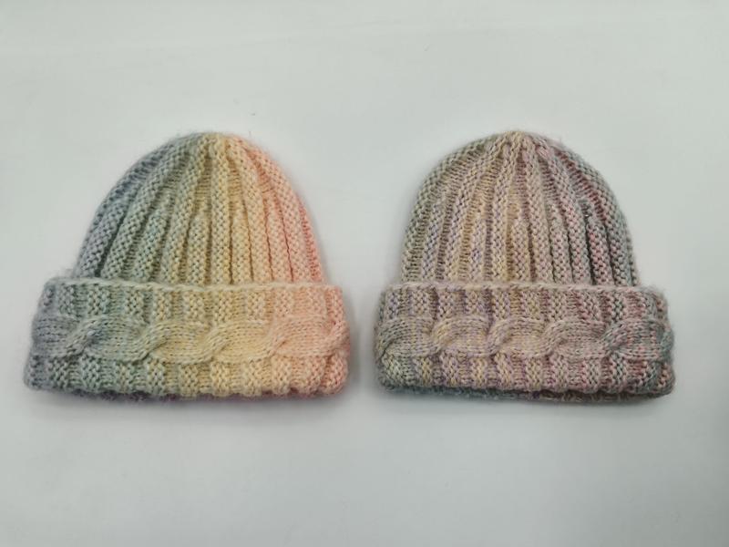 Zwei handgestrickte Beanies mit Zopfmuster-Bündchen, eine in Grün-Gelb-Pfirsich und eine in gedämpften Rosa-Taupe-Tönen