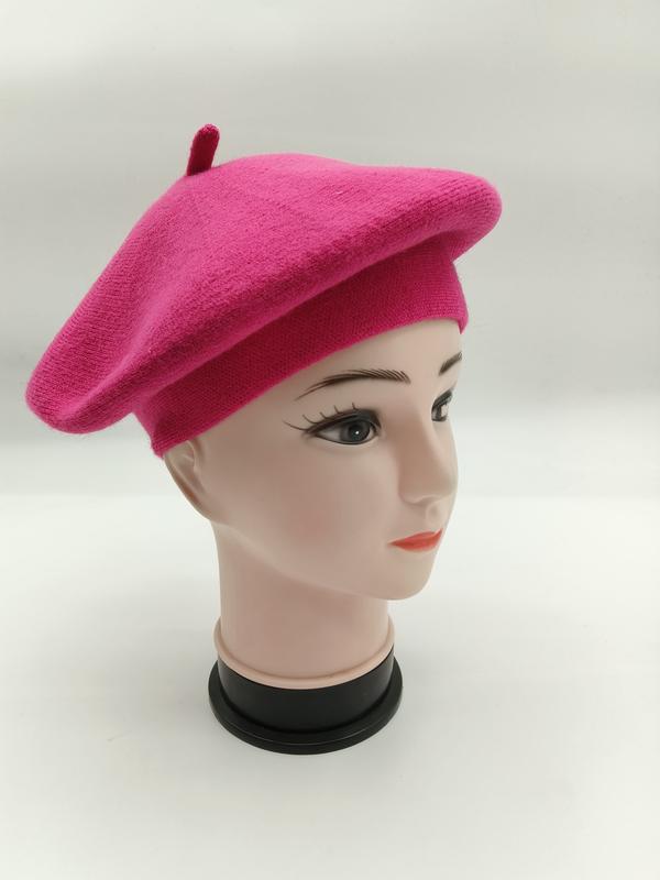 Pinkes Wollbarett mit rundem Schnitt und Zierknopf auf Mannequin-Kopf, Seitenansicht