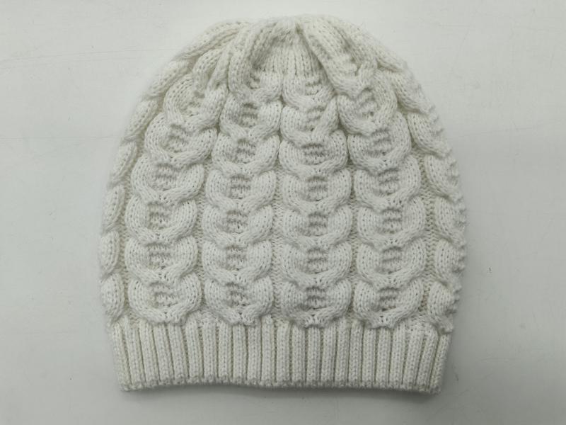 Weiße Zopfmuster-Wintermütze mit Blasenstich-Textur und gerippt abgesetztem Bündchen, auf hellem Hintergrund