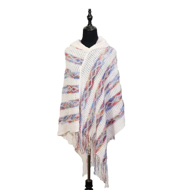 Elfenbeinfarbener Strickponcho mit Kapuze, buntem Streifenmuster in Rot und Blau sowie Fransenabschluss am Saum, auf schwarzer Schneiderpuppe präsentiert