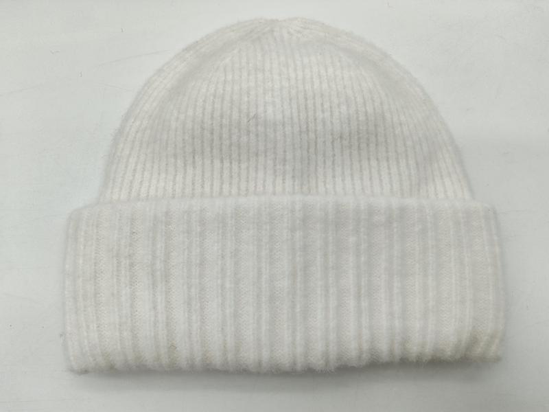Weiße Rippenstrickmütze mit doppelt umgeschlagenem Bündchen auf weißem Hintergrund, Flachaufnahme