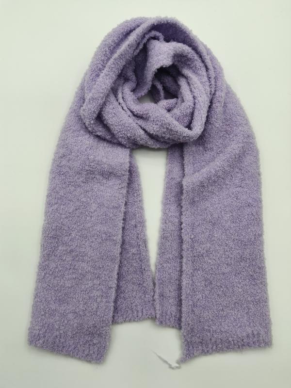 Weicher fliedervioletter Boucle-Strickschal locker aufgewickelt auf weißem Hintergrund mit fluffiger Gewebetextur und gerippten Enden