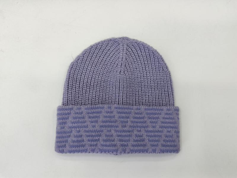 Lila Rippstrickmütze mit breitem gefaltetem Jacquard-Umschlag auf weißem Hintergrund