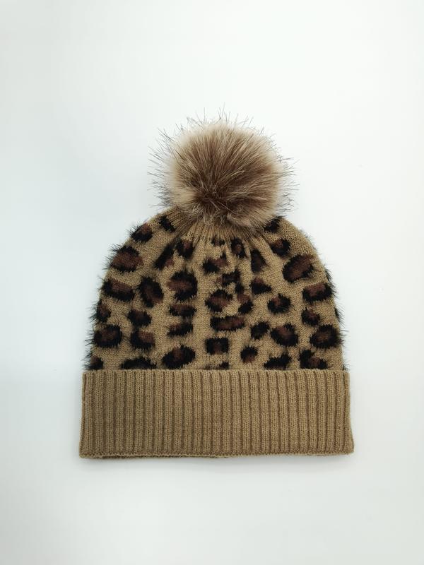Kamelbraune gestrickte Beanie im Leopardenprint mit fluffigem Kunstpelz-Bommel auf der Spitze – Draufsicht auf weißem Hintergrund