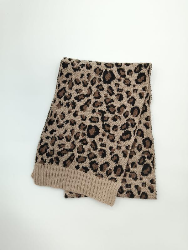 Gefalteter Strickschal mit Leopardenprint in Creme und Schwarz mit gerippten Abschlüssen auf weißem Hintergrund