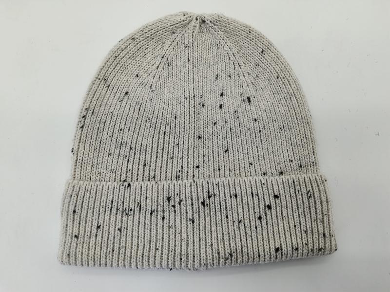 Hellgraue Strickmütze mit schwarzem Fleckenmuster und breitem umgeschlagenem Rippbündchen