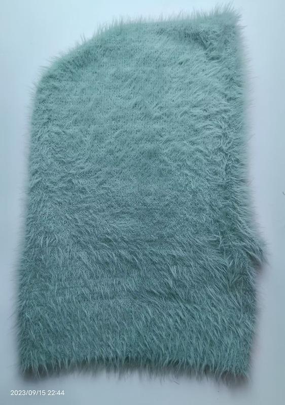 Mintgrüner Kunstfell-Stoff mit langem fluffigem Flor in Nahaufnahme auf weißem Hintergrund