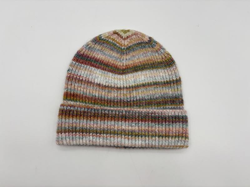 Gestrickte Wintermütze mit mehrfarbigen Space-Dye-Streifen in Rosa, Grün, Blau und Braun, gefaltetem Bündchen, auf weißem Hintergrund