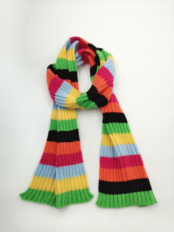 Langer Strickschal mit breiten bunten Querstreifen in Grün, Gelb, Orange, Pink, Blau und Schwarz auf hellem Untergrund