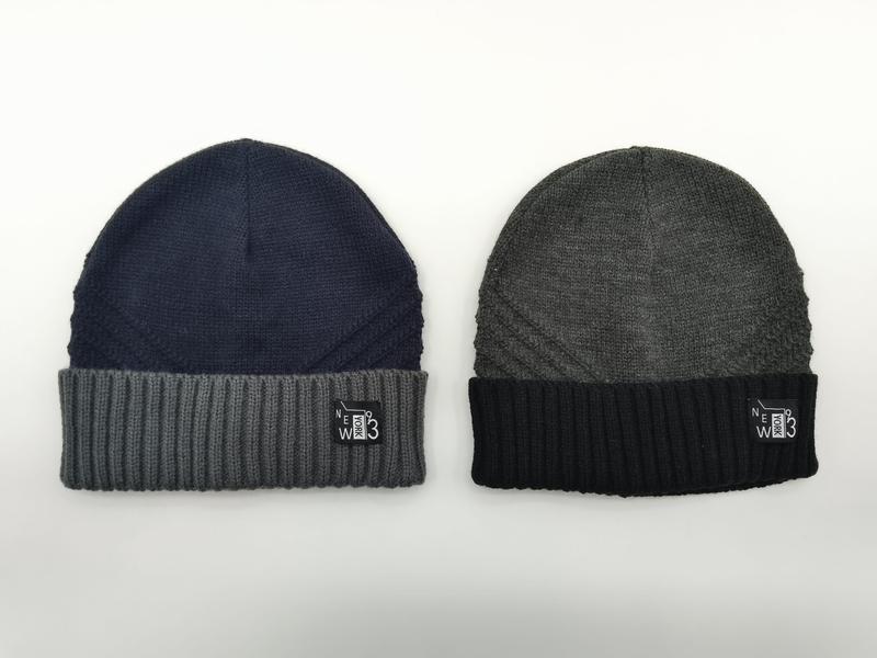 Zwei Strickmützen nebeneinander: Marineblau mit grauer Rippenkrempe und Anthrazit mit schwarzer Rippenkrempe, beide mit New-York-93-Aufnäher