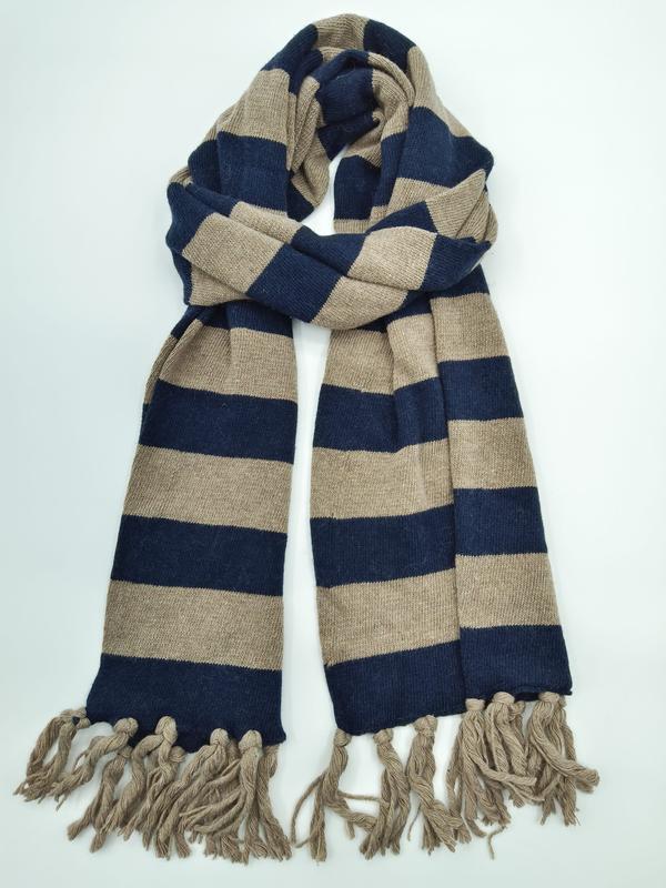 Breiter Strickschal mit marineblauen und beigefarbenen Blockstreifen sowie dekorativen Fransenquasten an den Enden