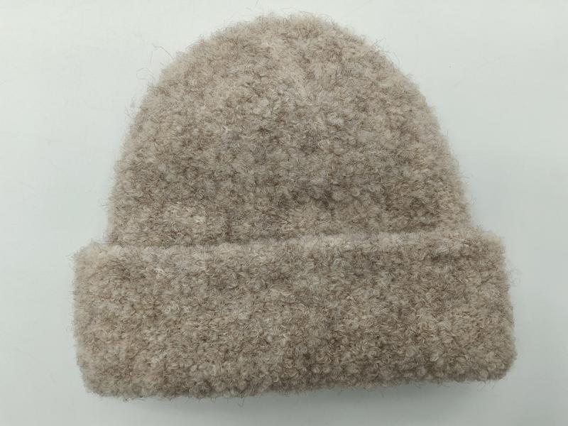 Beige-oatmeal Bouclé-Strickmütze mit Umschlag und flauschiger Garnstruktur, Draufsicht auf weißem Hintergrund