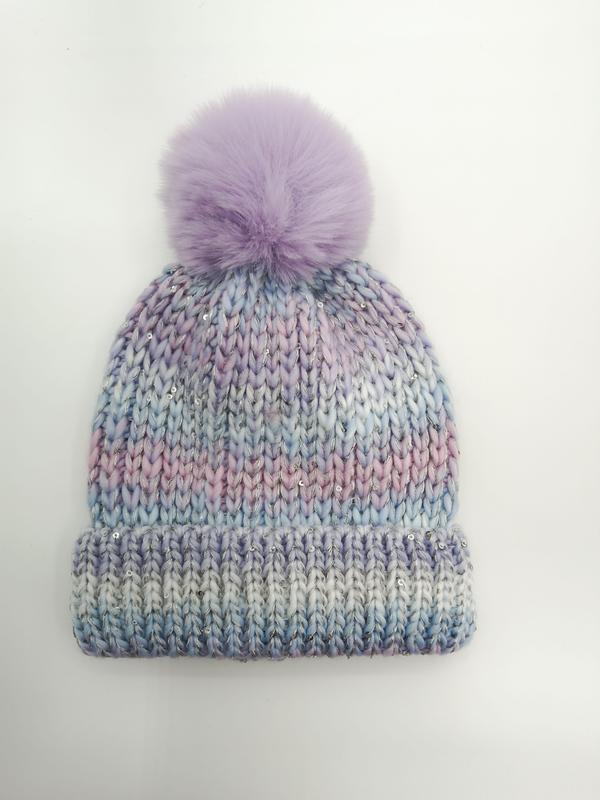 Grob gestrickte Beanie in Pastell-Ombre aus Lila, Blau und Rosa mit silbernen Pailletten und lavendelfarbenem Kunstfell-Bommel auf weißem Hintergrund
