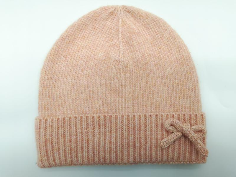 Weiche pfirsichfarbene Melange-Strickmütze mit gefaltetem Rippenbündchen und dekorativem gestricktem Schleifenapplikation