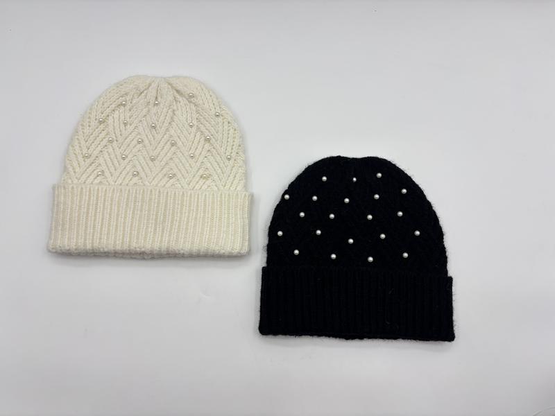 Zwei Rippenstrickmützen nebeneinander – eine in Creme mit Chevronmuster und eine in einfarbigem Schwarz, beide mit Perlenmotiven und Umschlagbündchen