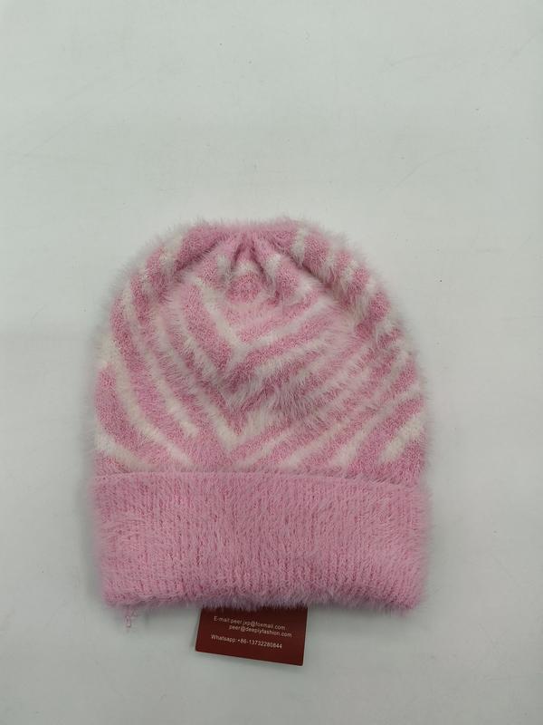Rosa-weiße Flausch-Strickmütze mit geometrischem Chevron-Streifenmuster und umgeschlagenem Rand in Draufsicht auf weißem Hintergrund