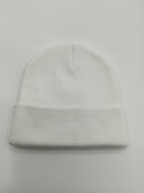 Weiße Strickmütze mit feinem Rippenmuster und gerolltem Bündchen, flach auf hellem Untergrund fotografiert, sichtbare Naht an der Spitze
