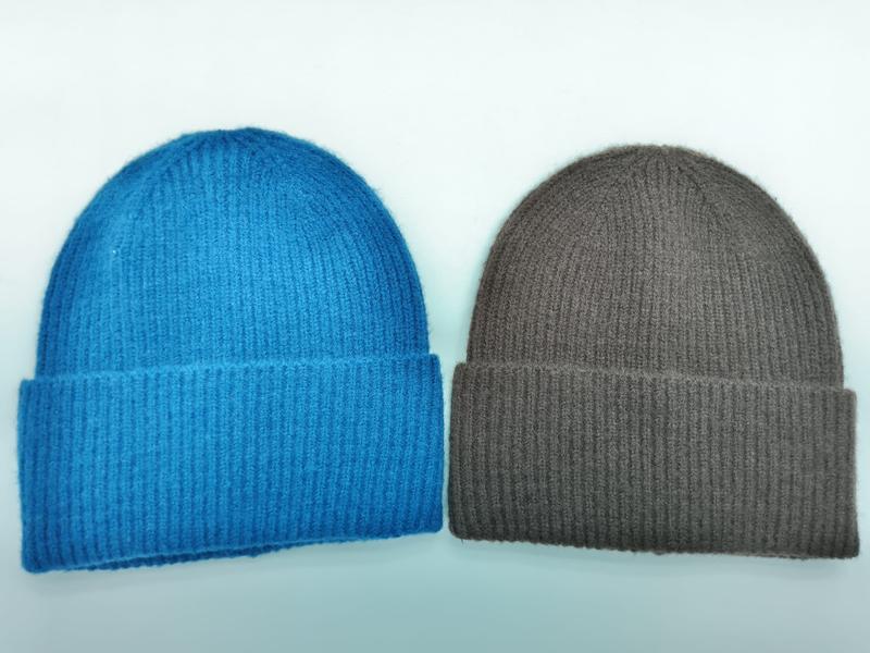Zwei Rippenstrick-Beanies mit Umschlagbündchen nebeneinander – eine in kräftigem Blau, eine in warmem Sandbraun, auf weißem Hintergrund