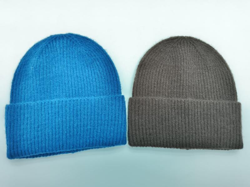 Zwei Umschlagbeanies aus Rippenstrick in leuchtendem Blau und warmem Hellbraun auf weißem Hintergrund nebeneinander