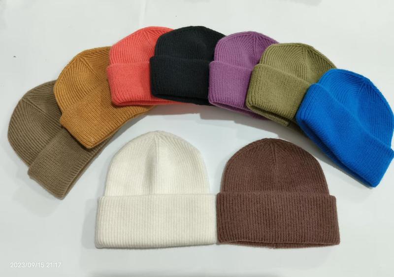 Kollektion aus 10 gerippten Strickmützen mit Umschlagbündchen in verschiedenen Farben wie Weiß, Schwarz, Rot, Blau, Lila, Olive, Braun und Kamel auf weißem Hintergrund