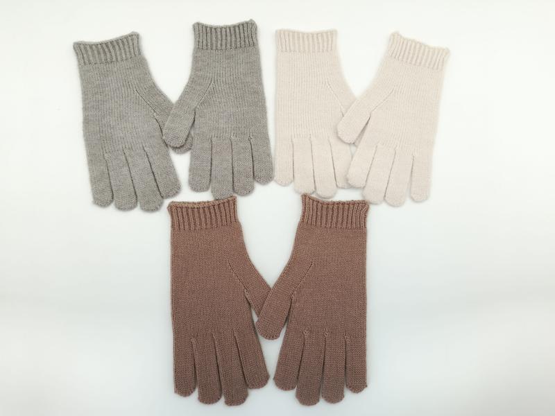 Drei Paare gerippter Winterhandschuhe in Hellgrau, Cremeweiß und Mauve-Rosa nebeneinander auf weißem Hintergrund