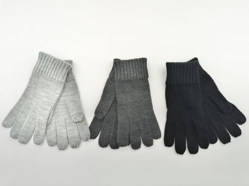 Drei Paar Rippenstrick-Winterhandschuhe in Hellgrau, Anthrazitgrau und Schwarz, flach auf weißem Untergrund ausgelegt