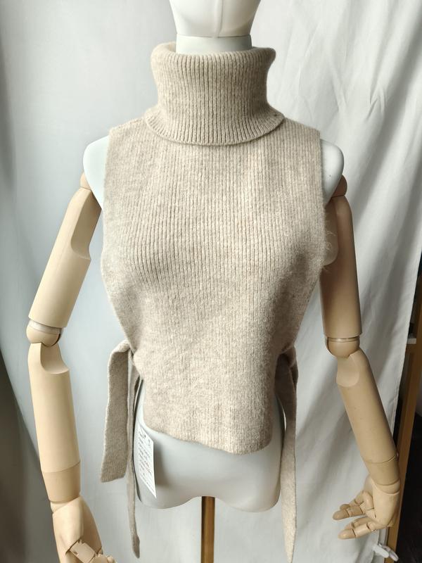Haferbeige gerippte ärmellose Rollkragen-Strickweste mit Bindegürtel an der Taille auf einer Schaufensterpuppe, neu mit Etikett