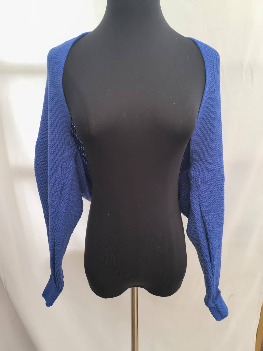 Royalblaue Kurzstrickjacke mit Grobmuster und langen Ärmeln auf schwarzer Kleiderpuppe