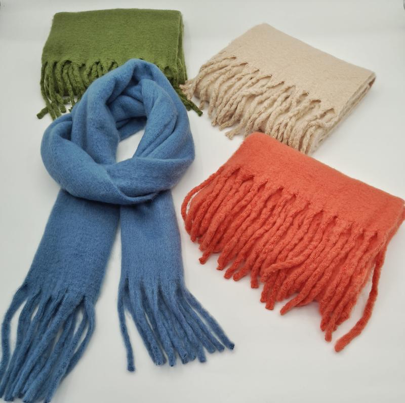 Vier Wollmix-Schals mit Fransen in Blau, Olivgrün, Beige und Korallorange, nebeneinander auf weißem Hintergrund präsentiert