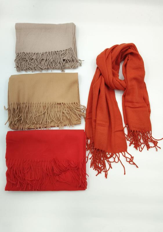 Vier unifarbene Schals im Pashmina-Stil mit weichen Fransenkanten in Beige, Kamelbraun, Rot und Terrakotta – einer ausgelegt, drei gefaltet auf weißem Hintergrund