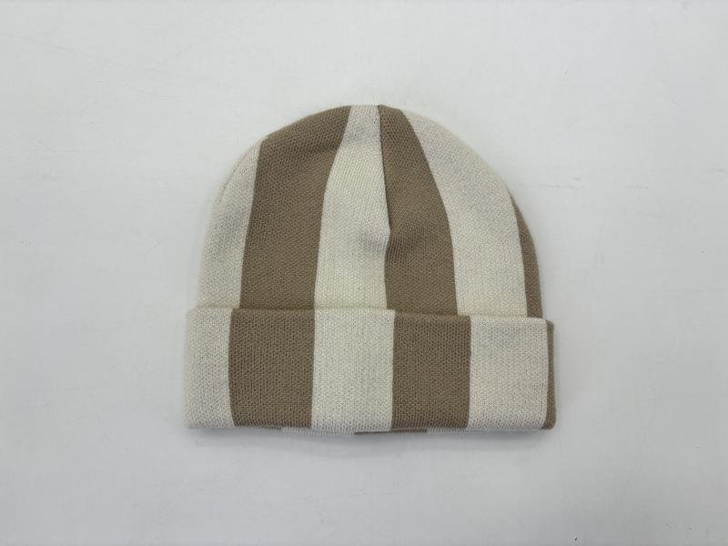 Flachliegende Strickmütze mit breiten senkrechten Streifen in Beige und Naturweiß mit Umschlagrand, auf weißem Untergrund