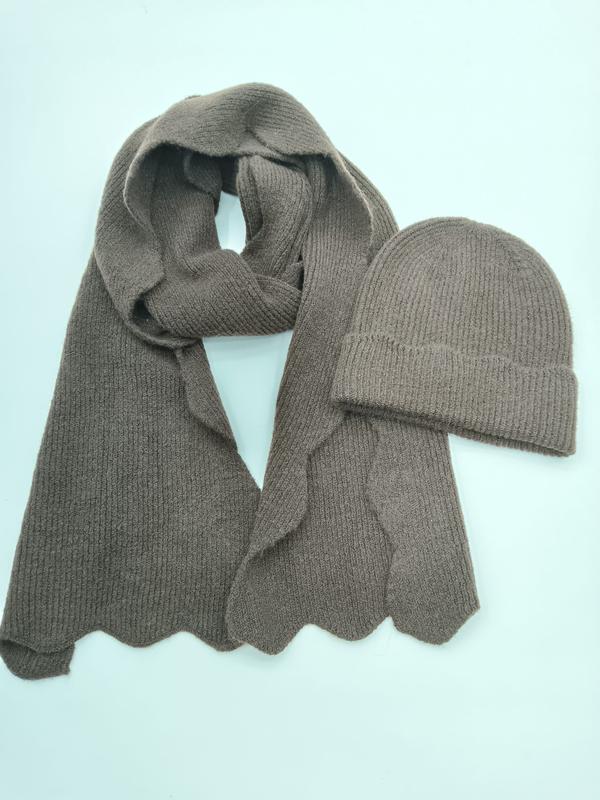 Taupefarbenes Rippenstrick-Set mit langem Schal mit Wellensaum und passender Umschlag-Beanie auf hellem Untergrund