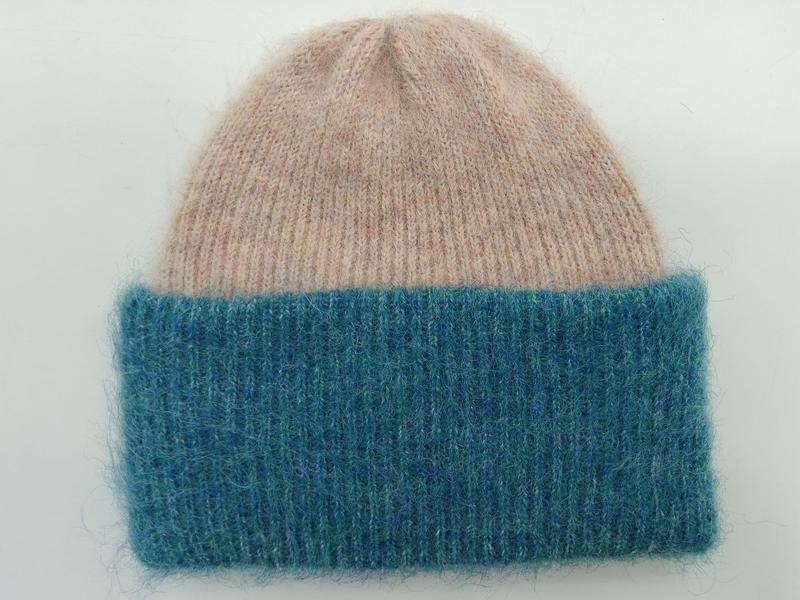 Flauschige Strickmütze mit weichem Oberteil in Altrosa und breitem geribbtem Umschlag in Petrolblau, Flachaufnahme auf hellem Hintergrund