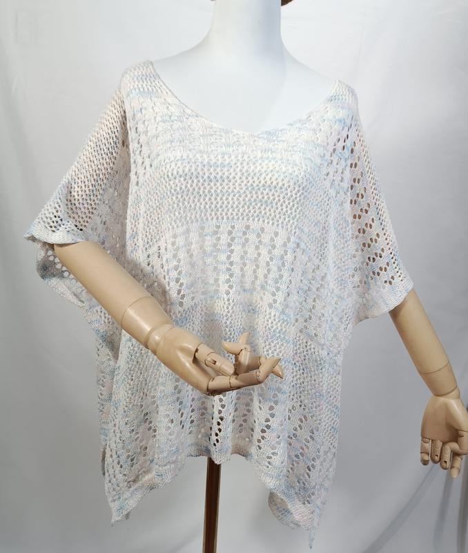 Weiß-blaues Multicolor-Häkel-Poncho-Top mit Kurzarm auf einer Schneiderpuppe, halbtransparentes Spitzenmuster in der Gesamtansicht