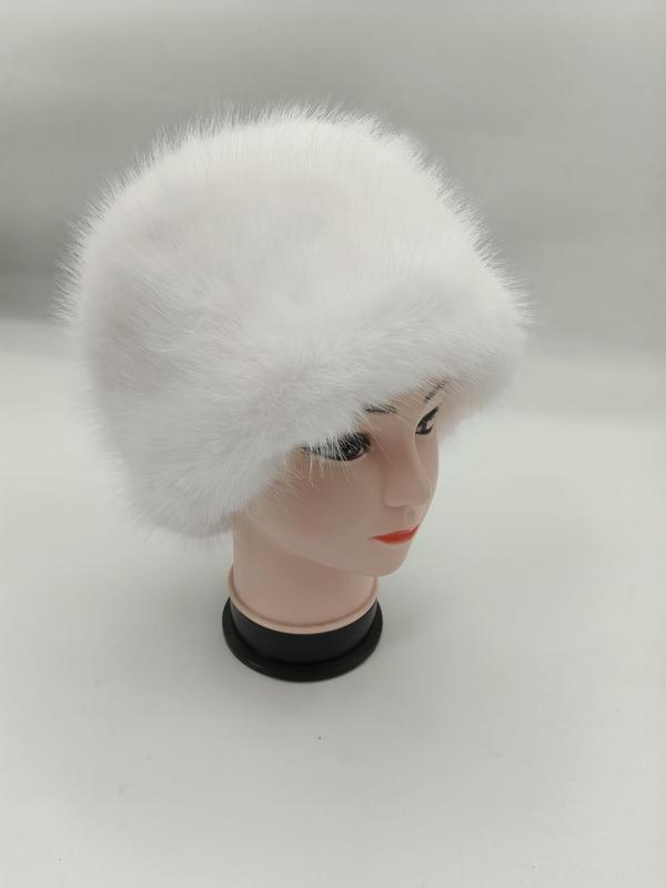 Weißer fluffiger Kunstpelzhut im Kosakendesign auf einer Hutform, vor hellgrauem Hintergrund