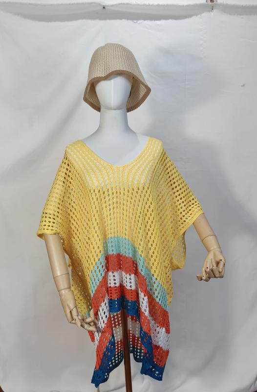 Schaufensterpuppe mit gelbem Häkel-Strandponcho und farbigen Streifen in Türkis, Orange, Weiß und Blau am Saum sowie beigem Bucket Hat